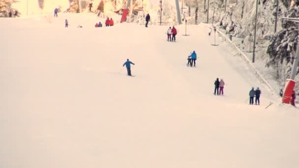 スキー観光客は日没時にスキーリフトの斜面に登る. — ストック動画