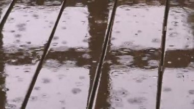 Yağmur Damlaları 'nın arka planı. Yağmur damlaları düşer ve suda daireler çizer. Yağmur mevsimi hüzün ve hayaller için harika bir zamandır..