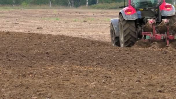 種子を播種するためのトラクターで土地を耕す 農地で作物を育てるための土壌の整備に取り組む — ストック動画