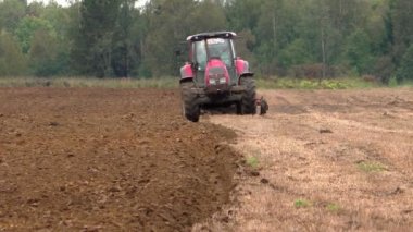 Tohum ekmek için toprağı traktörle sürüyorlar. Tarımsal alanda ekin yetiştirmek için toprağı hazırlamaya çalış..