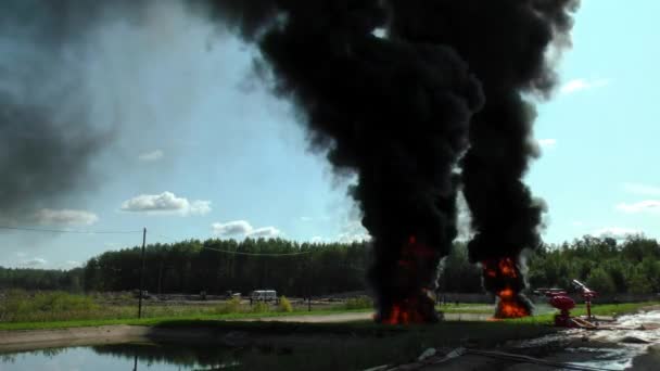 炎は炎の油から高い 消防士は水中で燃焼油を消火する — ストック動画