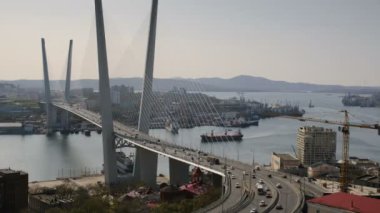 Deniz limanı denizi Vladivostok 'un panoramik manzarası, Rusya. Golden Horn Körfezi 'nin üzerinde yeni ve modern bir köprü. Gün batımında şehrin tepesinden panorama.