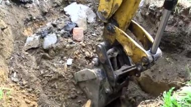 Kazıcının kovası yere bir çukur kazıyor..