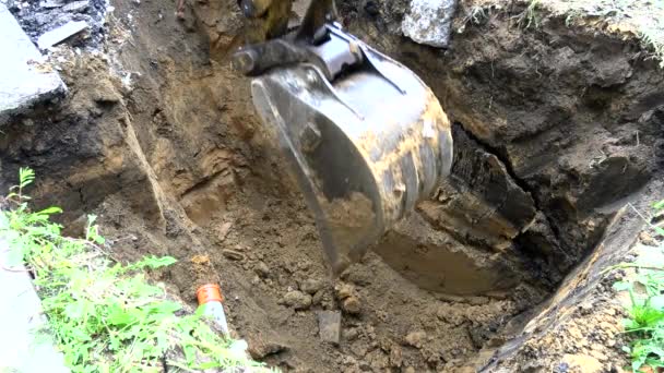 Відро екскаватора копає яму в землі . — стокове відео