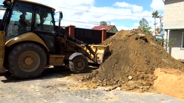 Il secchio dell'escavatore scava una buca nel terreno. — Video Stock