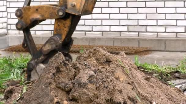 Il secchio dell'escavatore scava una buca nel terreno. — Video Stock