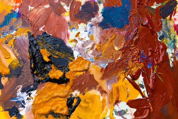 The palette of an artist painting in oil in nature. Background of mixing artistic colors.