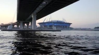 Saint Petersburg, Rusya, Gazprom Stadyumu 'nu geçerek köprünün altından geçiyor. Gün batımında tekneleri olan güzel bir deniz manzarası.