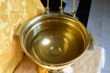 Kilisedeki bir çocuğun vaftiz töreni için bir yazı tipi. Hristiyan dininin töreni..