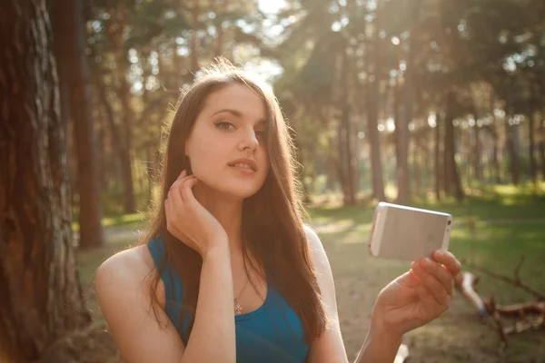 Menina bonita tirando uma selfie em uma tarde ensolarada — Fotografia de Stock