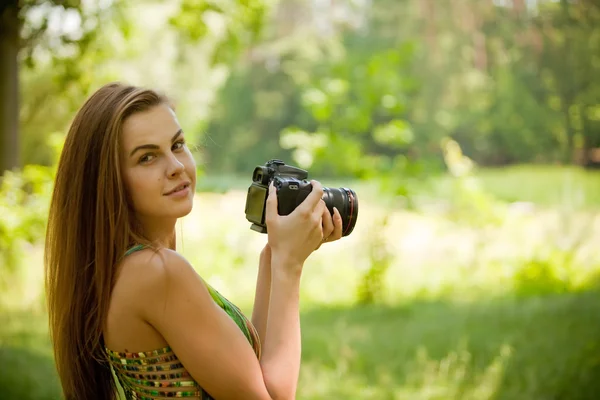 Girl taking pictures with a camera on nature — Stock Photo, Image