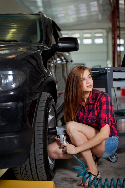 女机械师改变轮胎与气动冲击扳手 — 图库照片