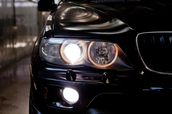 Headlights of black car. Garage theme — Stock Photo, Image