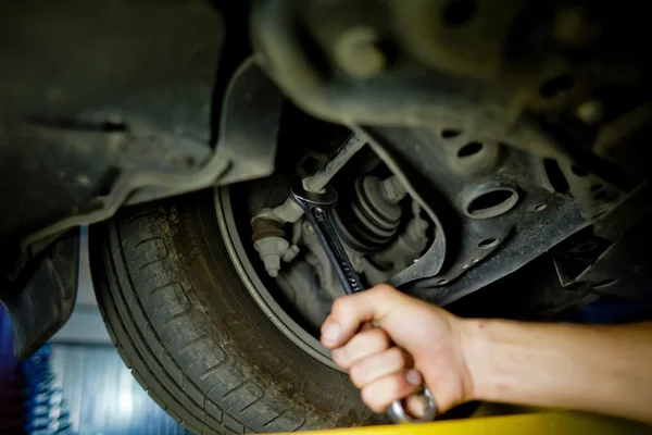 Elementem Auto mechanik praca pod podniesioną samochód — Zdjęcie stockowe