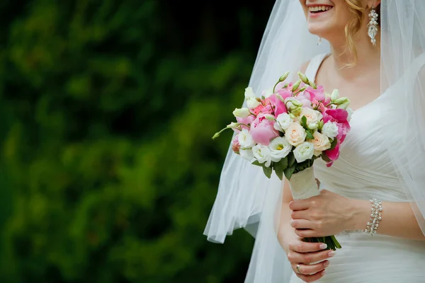 Jeune belle mariée avec bouquet dans les mains — Photo
