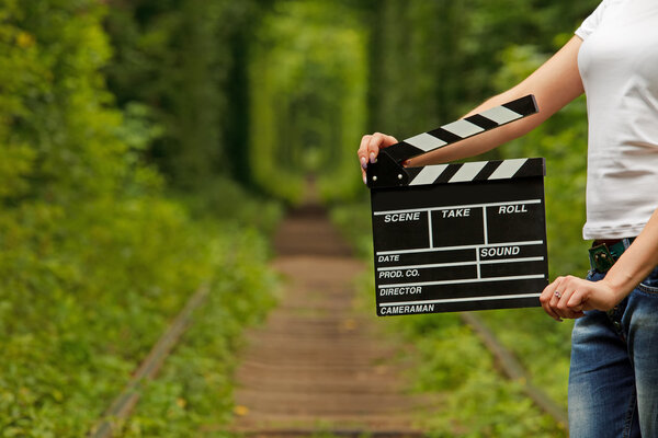Girl holding clapper board in her hands. tunnel of love in ukrai