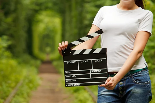 Woman holding clapper board in her hands. tunnel of love in ukra — Stock Photo, Image