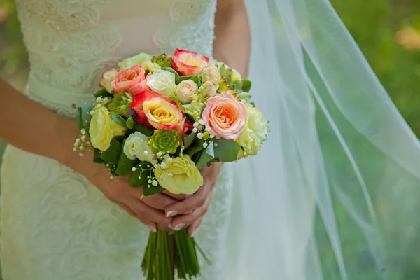 Schöne Hochzeitsblumen in den Händen der Braut. Hintergrund — Stockfoto