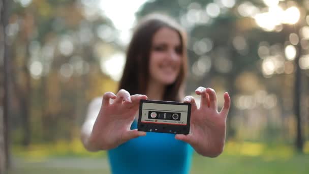 Meisje met een cassette in haar handen. Close-up — Stockvideo