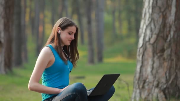 Jovem mulher bonita falando e trabalhando usando laptop — Vídeo de Stock