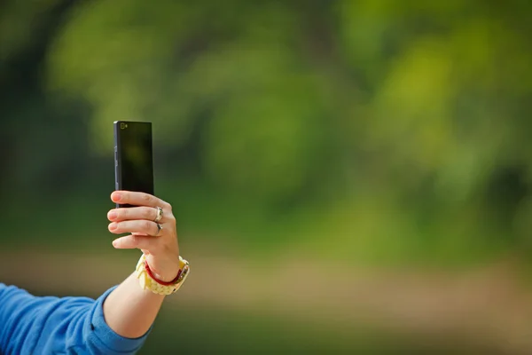 Mão feminina tira fotos com telefone inteligente móvel — Fotografia de Stock