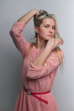 Genç kadın, kız sarışın uzun saç gri arka plan üzerinde çekici.