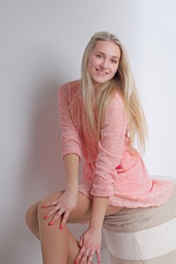 Pembe elbiseli seksi sarışın. Stüdyo. Dikey fotoğraf