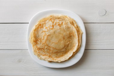 Beyaz ahşap bir masada güzel krepler. Üstte görüntü .