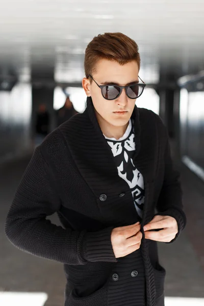 Κομψό νεαρός άνδρας στο μαύρο πουλόβερ και γυαλιά ηλίου σε μια ηλιόλουστη ημέρα — Φωτογραφία Αρχείου