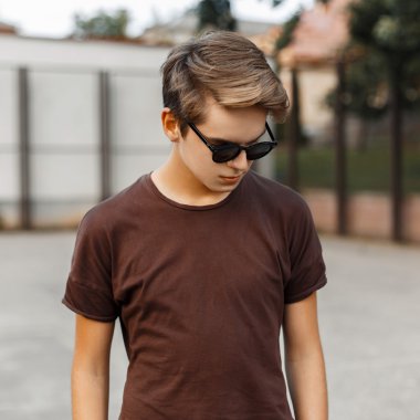 Şık güneş gözlüğü yakışıklı adam aşağı bakıyor.