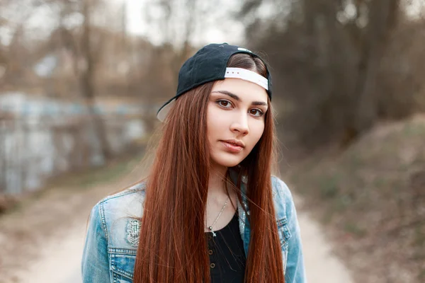 黒い野球帽とデニム ジャケットでかなり若い女性のクローズ アップの肖像画. — ストック写真