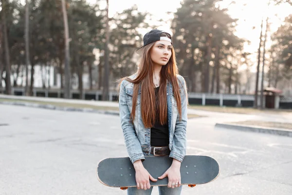 Schöne stylische Mädchen Hipster mit Skateboard an einem sonnigen Tag — Stockfoto