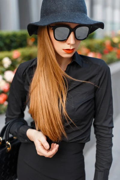 Elegante mujer de moda en gafas de sol, sombrero y camisa negra — Foto de Stock