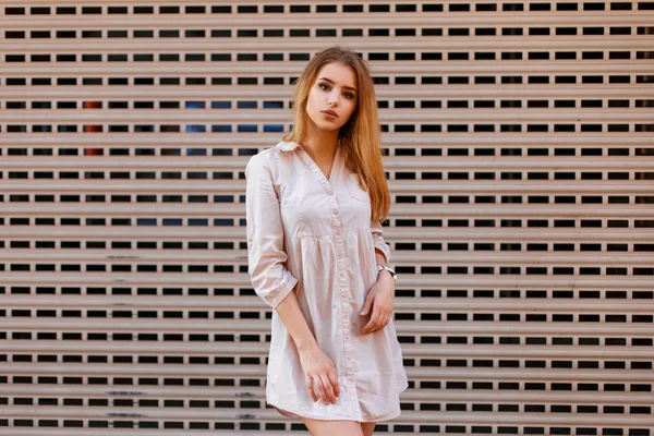Bella donna alla moda in abiti eleganti in posa vicino a una parete di metallo . — Foto Stock