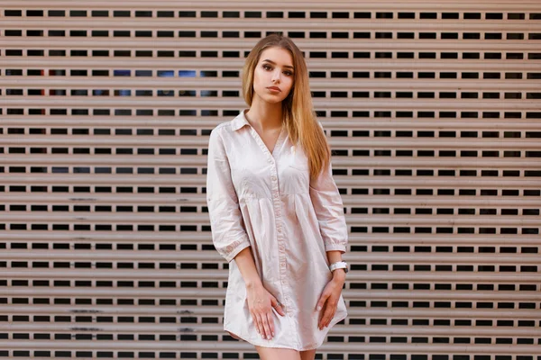 벽 근처에 있는 셔츠를 입고 있는 아름다운 소녀. — 스톡 사진