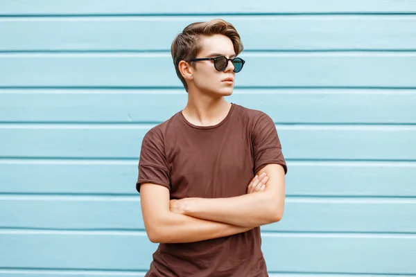 Tineri elegant frumos om este pozând lângă un perete albastru strălucitor . — Fotografie, imagine de stoc