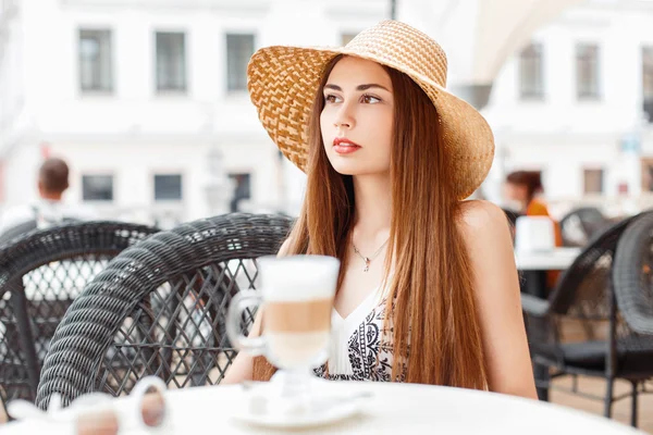 Hermosa chica elegante elegante se sienta en la cafetería de verano y beber café . — Foto de Stock