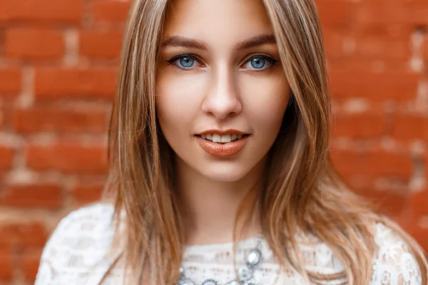 Beau portrait en gros plan d'une jolie femme aux yeux bleus sur fond rouge . — Photo