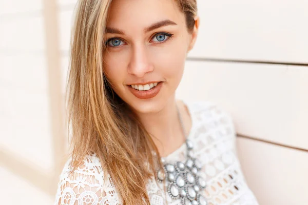 Veselá Mladá krásná žena s úsměvem a modrýma očima, které hledí do kamery — Stock fotografie