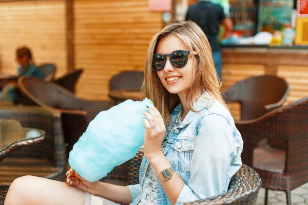 Alegre joven bonita chica con una sonrisa come algodón de azúcar en un día soleado . — Foto de Stock