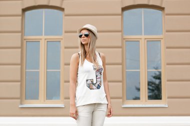 Kız güneş gözlüğü ve şapka ayakta evin yanında