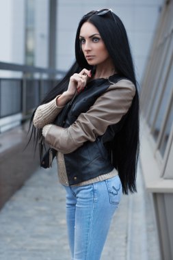 Kız bir deri ceket ayakta building yakınındaki