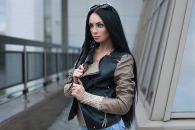 Kız bir deri ceket ayakta building yakınındaki