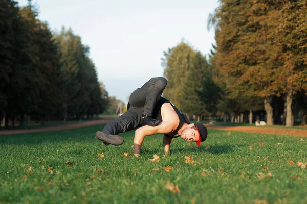 Man dancing in a red cap in the park — Stock Photo, Image