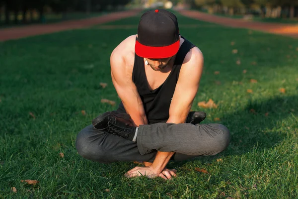 Man in a red cap stands on hands — Stock Photo, Image