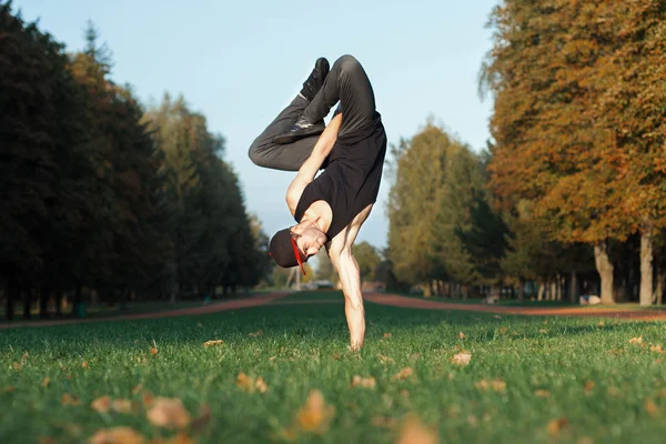 Dancer standing on hands in the park — Stock Photo, Image