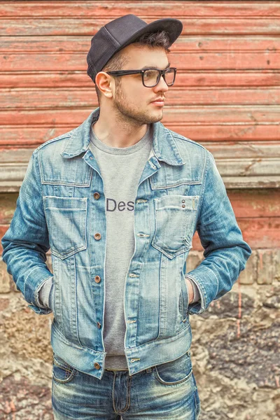 Man hands in pockets standing at wooden wall — Stock Photo, Image