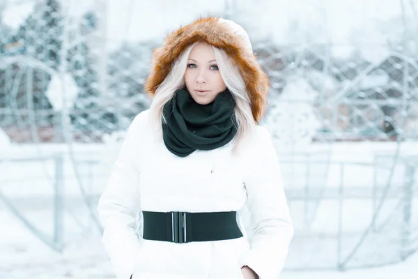 Hermosa mujer en una chaqueta de invierno se encuentra en la ciudad —  Fotos de Stock
