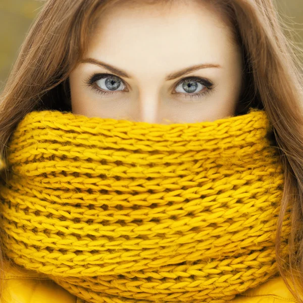 Hübsche Frau mit gelbem Strickschal, die in die Kamera blickt. beaut — Stockfoto