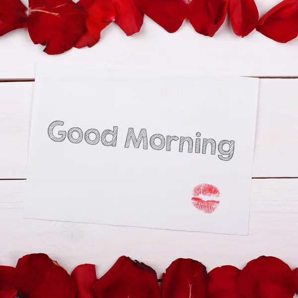 Sheet of paper Good Morning with a kiss. Note and rose petals